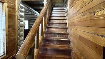 A wooden staircase with a wooden railing leading to a higher level.