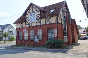 Ein zweistöckiges Gebäude im traditionellen Baustil, das Backstein und Fachwerk kombiniert.