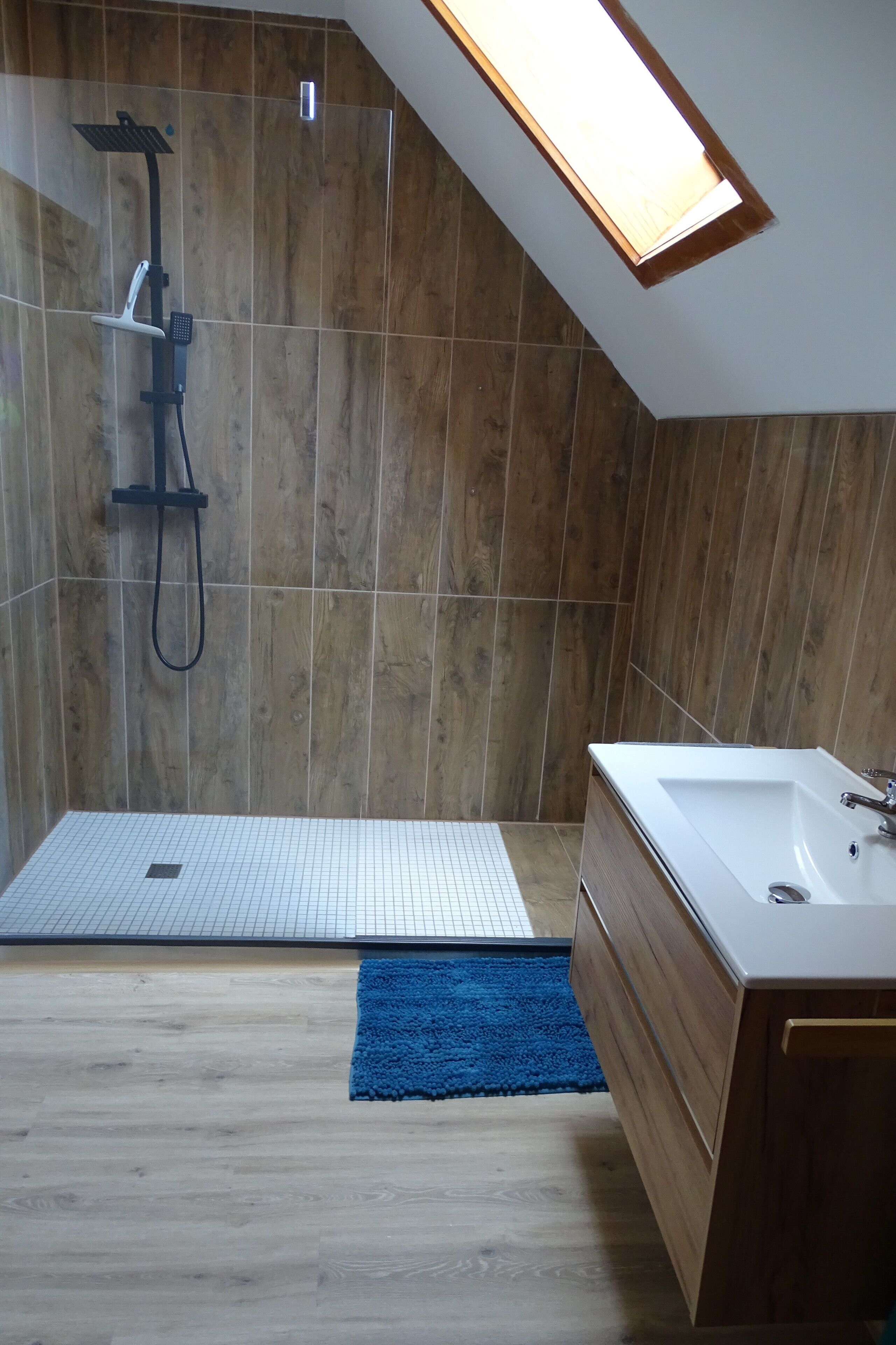 A modern bathroom with a shower, a bathtub, and a tiled floor.