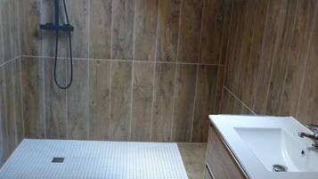 Un bagno moderno con doccia, vasca e pavimento piastrellato.