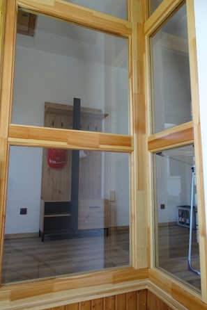 Ein Zimmer mit Holzboden, einem Holzkasten und einem roten Schild mit Text.