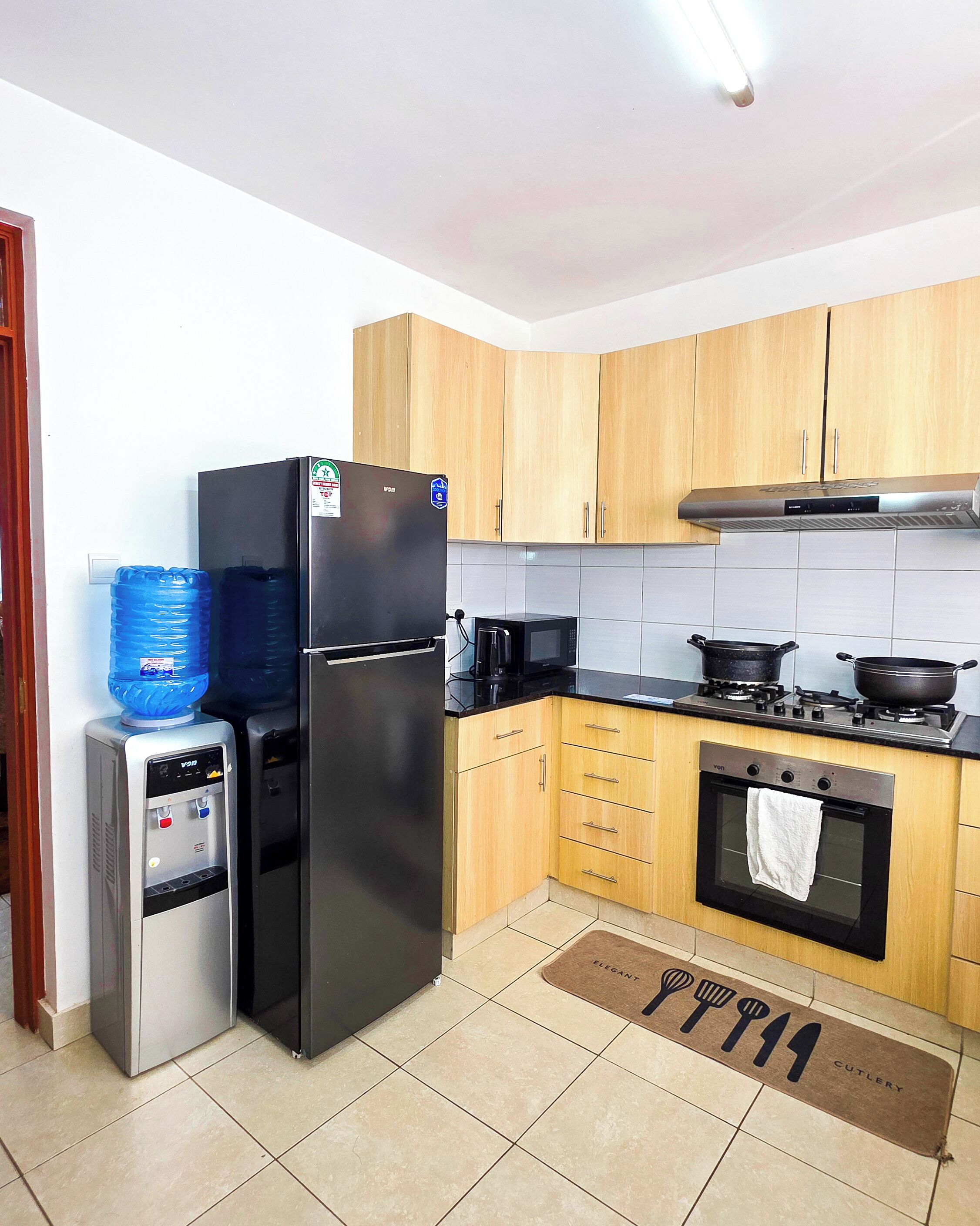 Eine Küche mit Kühlschrank, Mikrowelle, Herd und Backofen.
