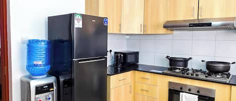 A kitchen with a refrigerator, microwave, stove, and oven.