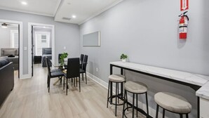 Un intérieur moderne comprenant un coin repas, des tabourets de bar et un extincteur fixé au mur.