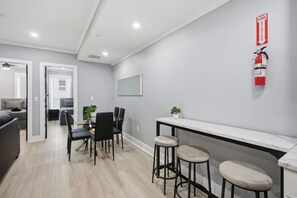 A modern interior with a dining area, bar stools, and a fire extinguisher on the wall.