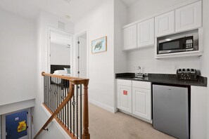 A modern kitchen with white cabinetry, a stainless steel microwave, and a built-in toaster. - Game Room • Arcade Games • Private Pool • Guest House • 7521 (Kissimmee)