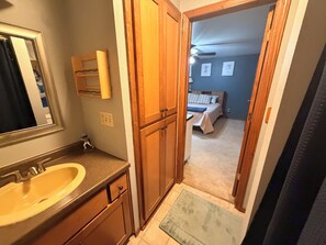 A bathroom with a sink, mirror, and wooden cabinets.
