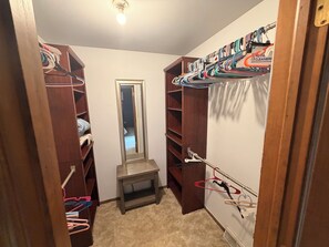 A walk-in closet with wooden shelving, a mirror, and a small table. - Spacious 5 bedroom kid friendly home. Private backyard. 1.5 miles from Lambeau (Green Bay)