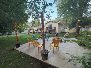 A backyard with a fire pit, outdoor furniture, and string lights. - Spacious 5 bedroom kid friendly home. Private backyard. 1.5 miles from Lambeau (Green Bay)