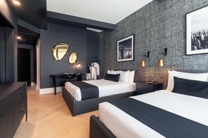 Ein modernes Hotelzimmer mit zwei Betten, einem Schreibtisch, einem Stuhl, einem Kleiderschrank und einem Spiegel.