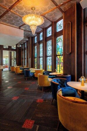 A restaurant interior with wooden paneling, stained glass windows, and plush seating. - Two-Bedroom Suite by Madison Square Park (New York)