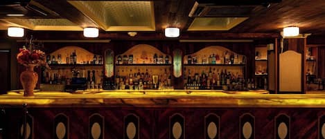 Un bar con techo de madera y estantes llenos de botellas.