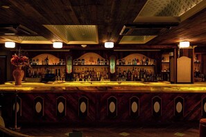 Eine Bar mit Holzbalkendecke und Regalen voller Flaschen.