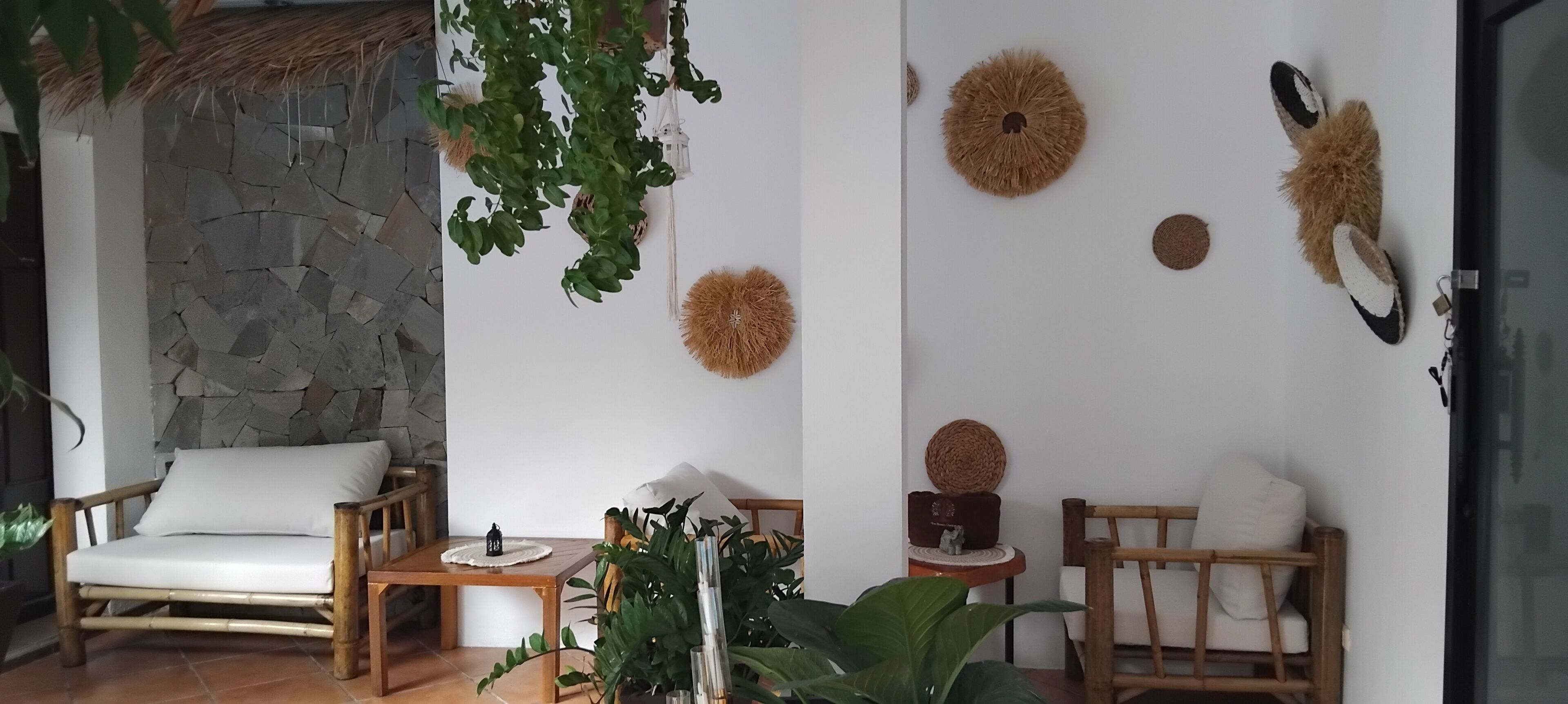 A room with a stone wall, a wooden chair, a table, and decorative wall hangings.