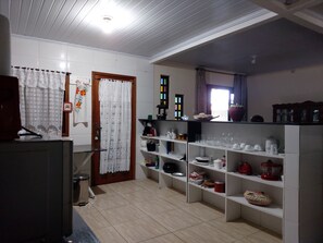 A kitchen with white cabinets, a refrigerator, and a countertop with various kitchen items.