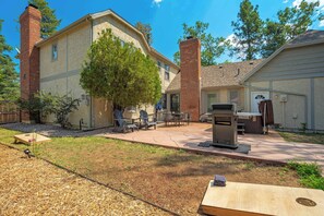 A residential backyard with a patio, outdoor seating, and a barbecue grill. - Starsmore Manor! Walk to Broadmoor w/ Hot Tub (Colorado Springs)