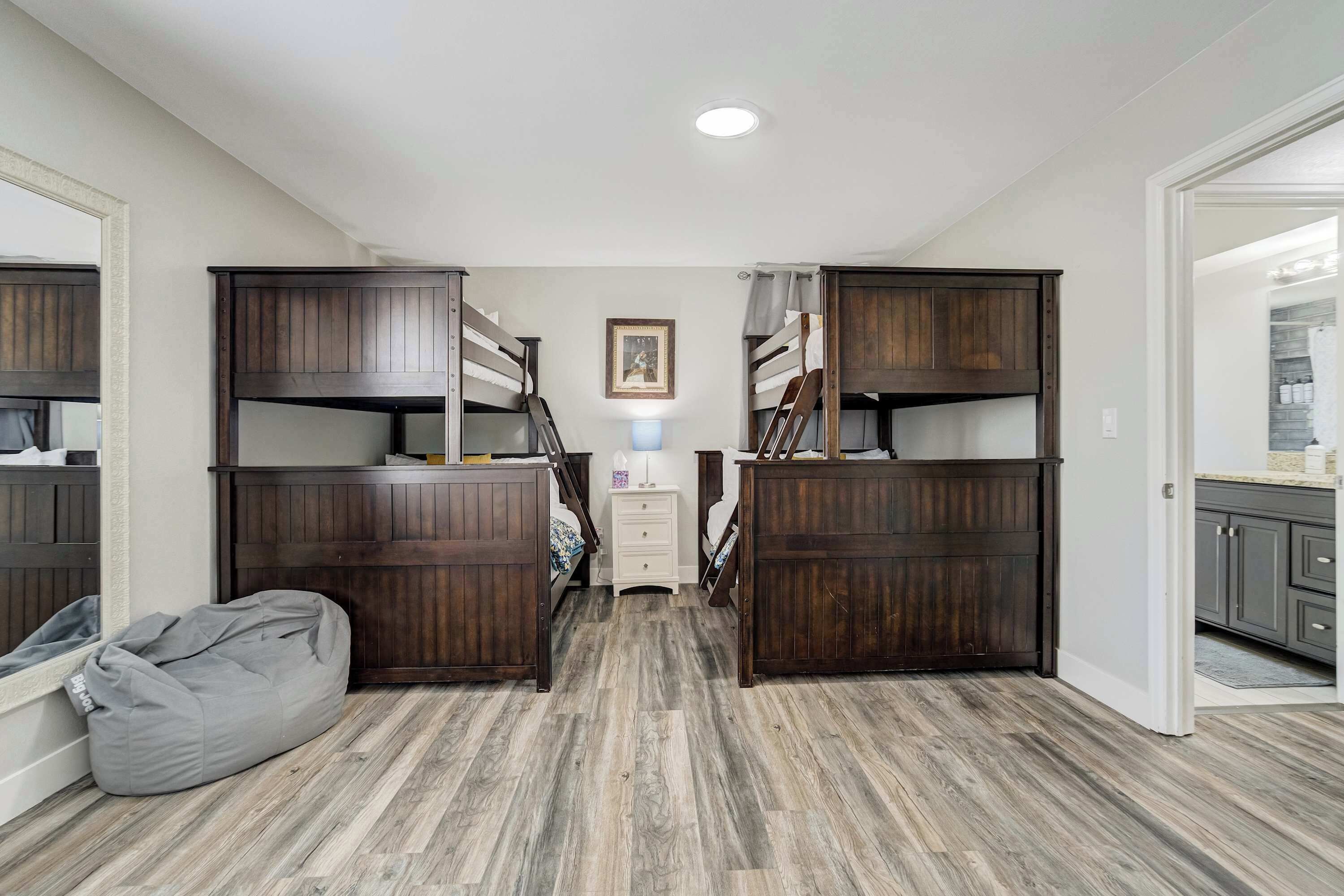 Een kamer met stapelbedden, een bureau en een stoel.