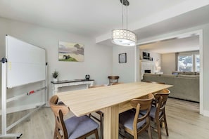 Ein Essbereich mit Holztisch und -stühlen, einer Tafel und einem Bild an der Wand.