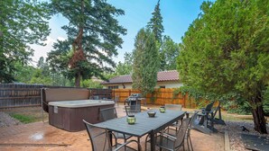 Eine Außenpatio mit Whirlpool, Grill und Essbereich.