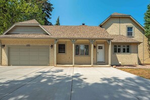 A two-story house with a garage, a covered porch, and a small front yard. - Starsmore Manor! Walk to Broadmoor w/ Hot Tub (Colorado Springs)