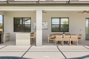 A modern outdoor patio with a pool, a dining area with wicker furniture, and a grill. - The Premiere House - 8 Mins to Universal Studios 3 Mins to Sea World 15 Mins to Disney World (Orlando)