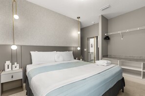A modern bedroom with a large bed, bedside tables, a mirror, and a hanging light fixture. - The Premiere House - 8 Mins to Universal Studios 3 Mins to Sea World 15 Mins to Disney World (Orlando)