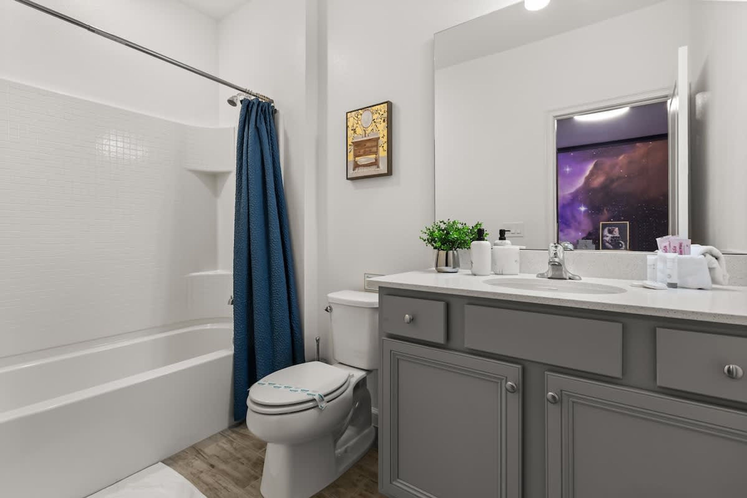 Une salle de bain moderne équipée d’une douche, de toilettes et d’un meuble-lavabo avec un miroir.