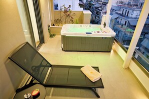 A balcony with a seating area, a hot tub, and a view of the cityscape. - Luxury Athens Duplex with Acropolis View, Private Heated Jacuzzi & Parking (Athina)