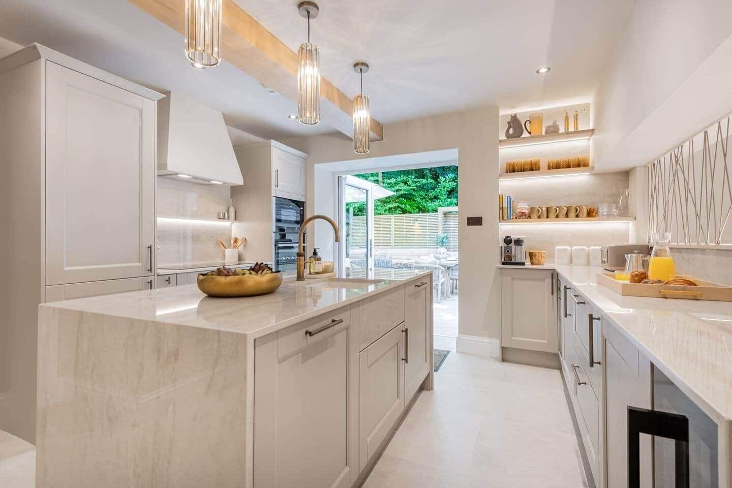A modern kitchen with a central island, pendant lighting, and a view to the outdoors.