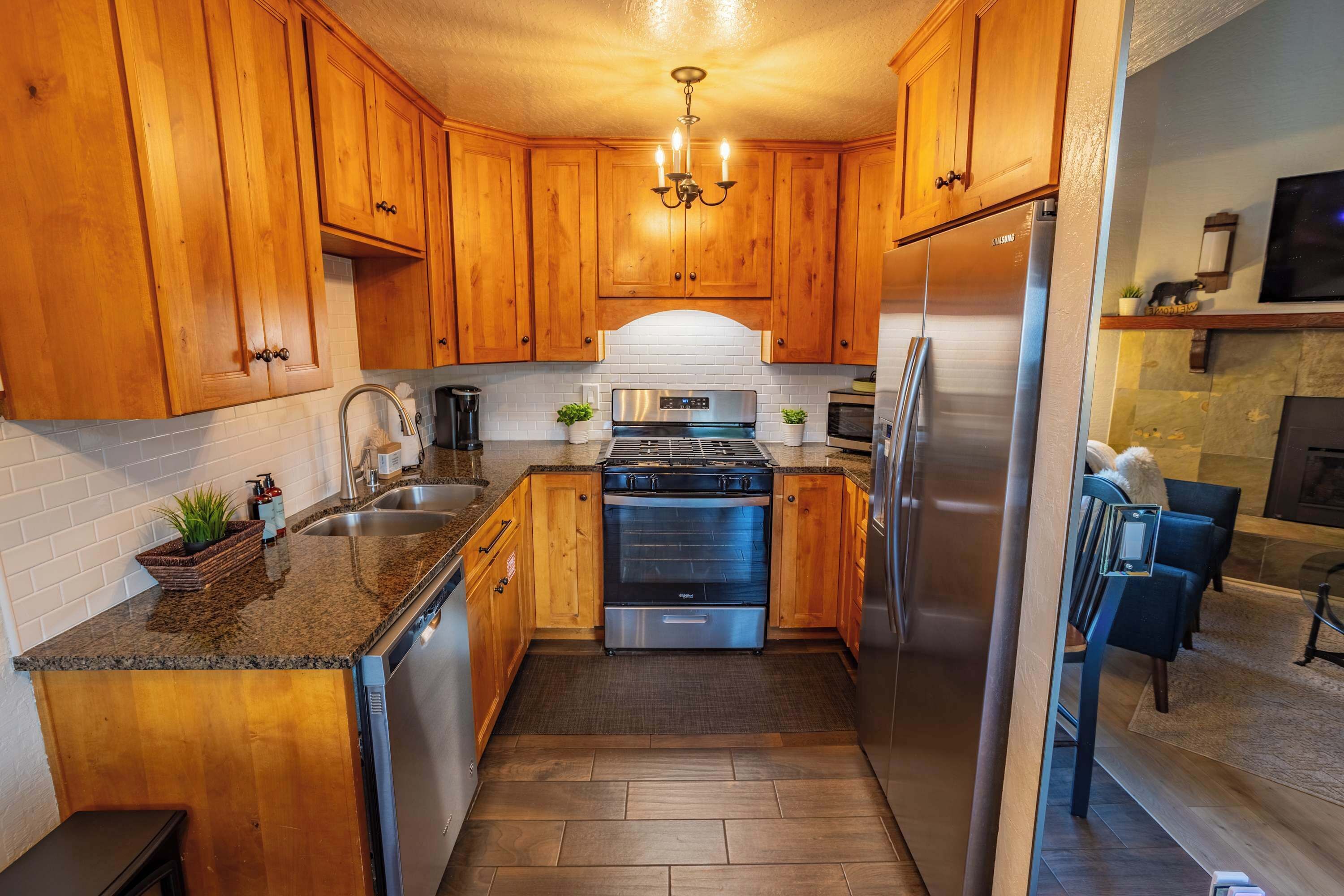 A modern kitchen with wooden cabinets, stainless steel appliances, and a built-in oven.