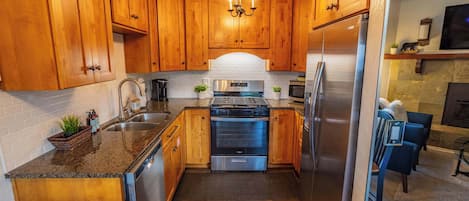 Una cocina moderna con armarios de madera, electrodomésticos de acero inoxidable y un horno empotrado.