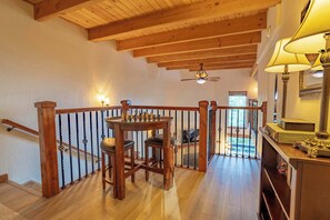 A wooden-floored room with a chess table, a staircase with a railing, and a ceiling fan. - Heavenly Vista Lago Lake View - Luxury Ski-In-Ski-Out Retreat with Stunning Lake Views (Stateline)