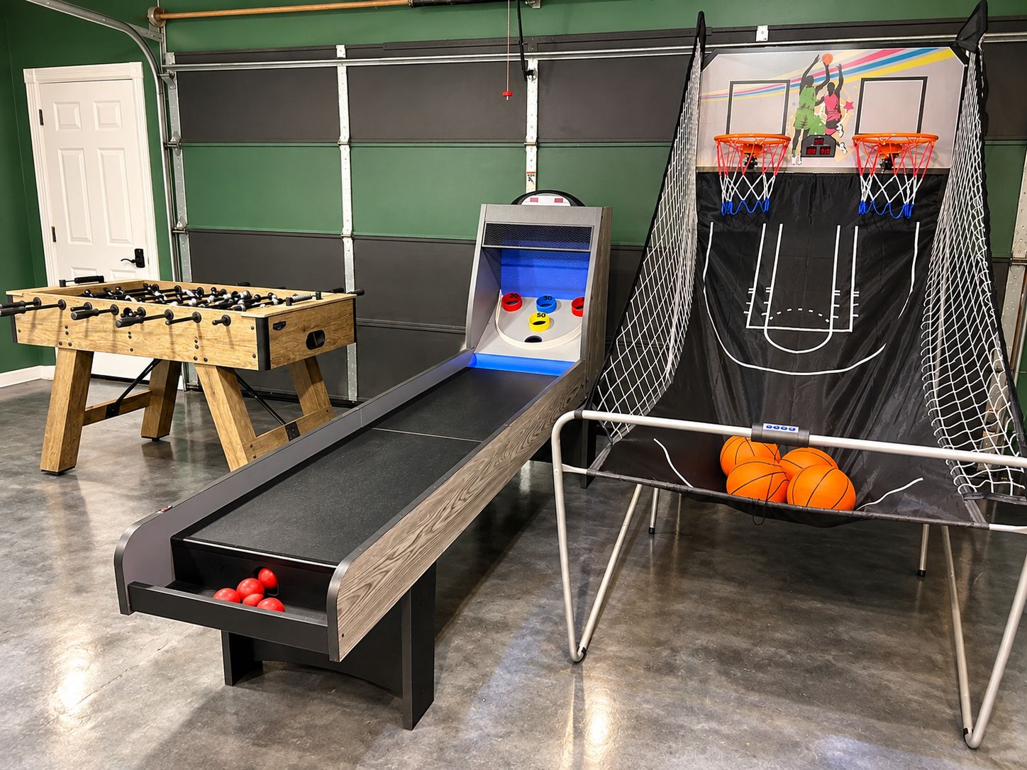 A recreational area with a foosball table, a bowling alley, and a basketball hoop.