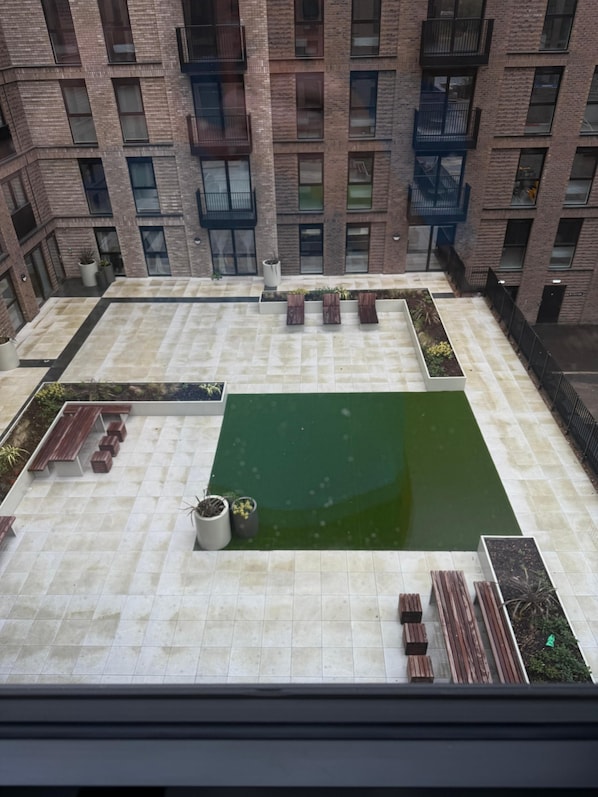 Eine Dachterrasse mit Pool, Sitzbereichen und Blumentöpfen.