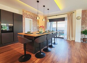 Eine moderne Küche mit Kochinsel, Barhocker und Essbereich mit Aussicht.