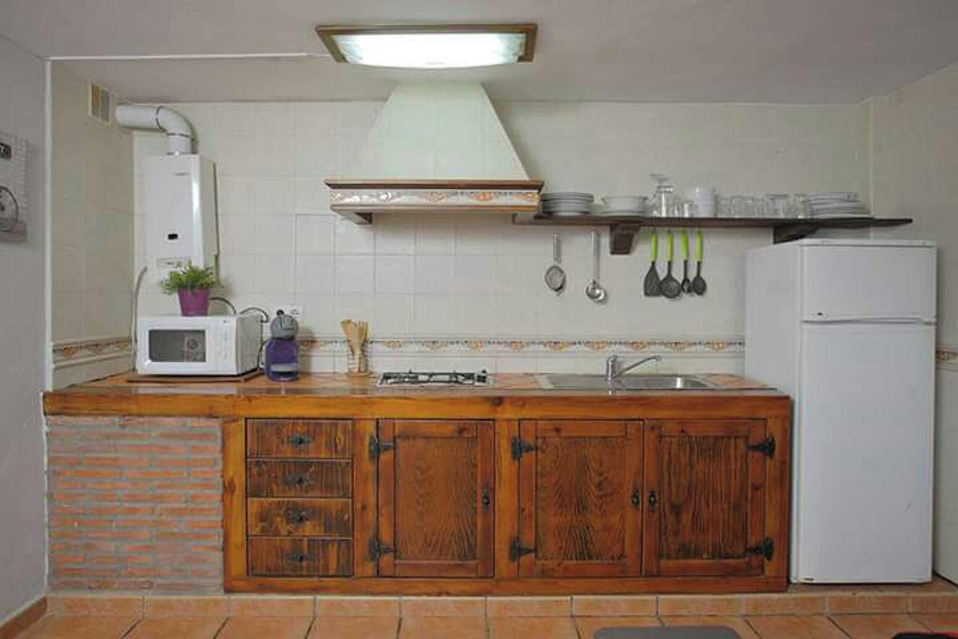 A compact kitchen with a microwave, stove, and sink.