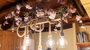 Eine Küche mit Holzausstattung, einem weißen Kühlschrank und einer Decke mit Seilen und Blumen.