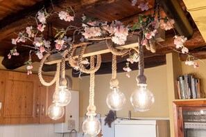 Eine Küche mit Holzausstattung, einem weißen Kühlschrank und einer Decke mit Seilen und Blumen.