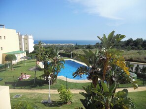 Une piscine entourée d’une végétation luxuriante, avec vue sur la mer.