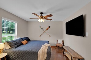 A bedroom with a bed, a ceiling fan, a TV, and a window with blinds. - Two homes- 5 bedrooms on beautiful private lake. (Long Branch)