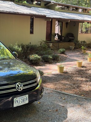 A green Volkswagen parked in front of a yellow building with a brick pathway leading to a porch. - Private gorgeous retreat on the golf course in Carolina Trace (Sanford)