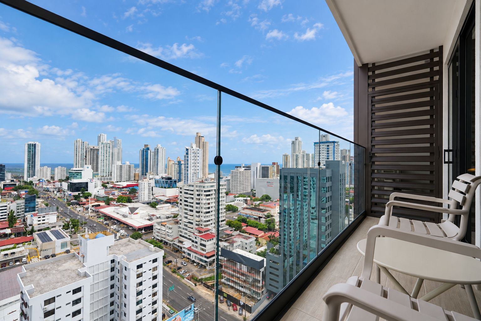 A balcony with a city view, including high-rise buildings and a clear sky.