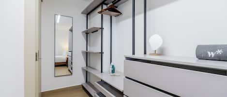 Un baño moderno con tocador, espejo y perchero.