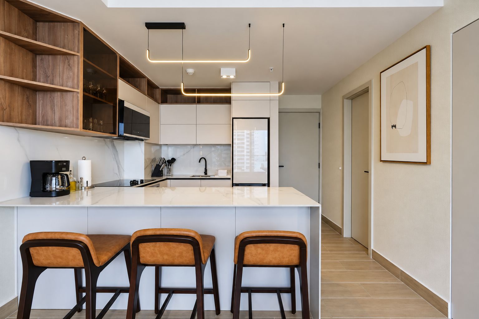 Una cocina moderna con una isla central, taburetes de bar e iluminación colgante.