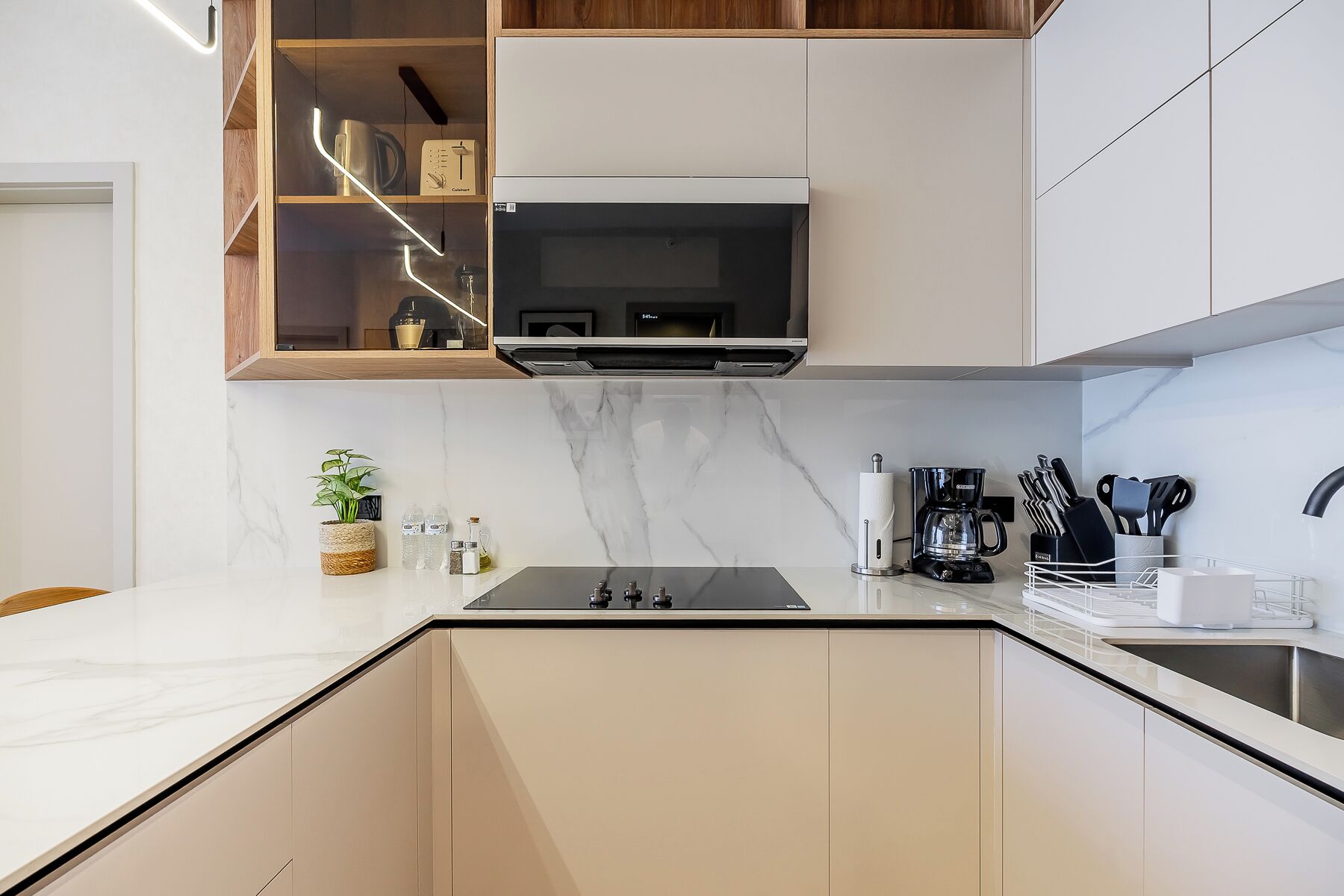 A modern kitchen with a built-in microwave, a coffee maker, and a knife block.