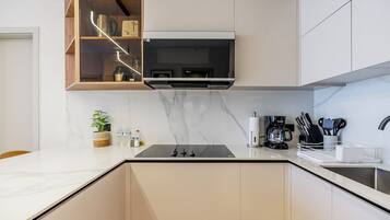 A modern kitchen with a built-in microwave, a coffee maker, and a knife block.