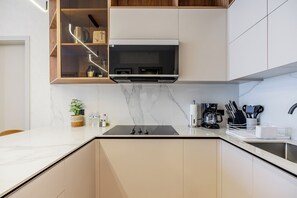 Eine moderne Küche mit integriertem Mikrowellenherd, einer Kaffeemaschine und einem Messerblock.