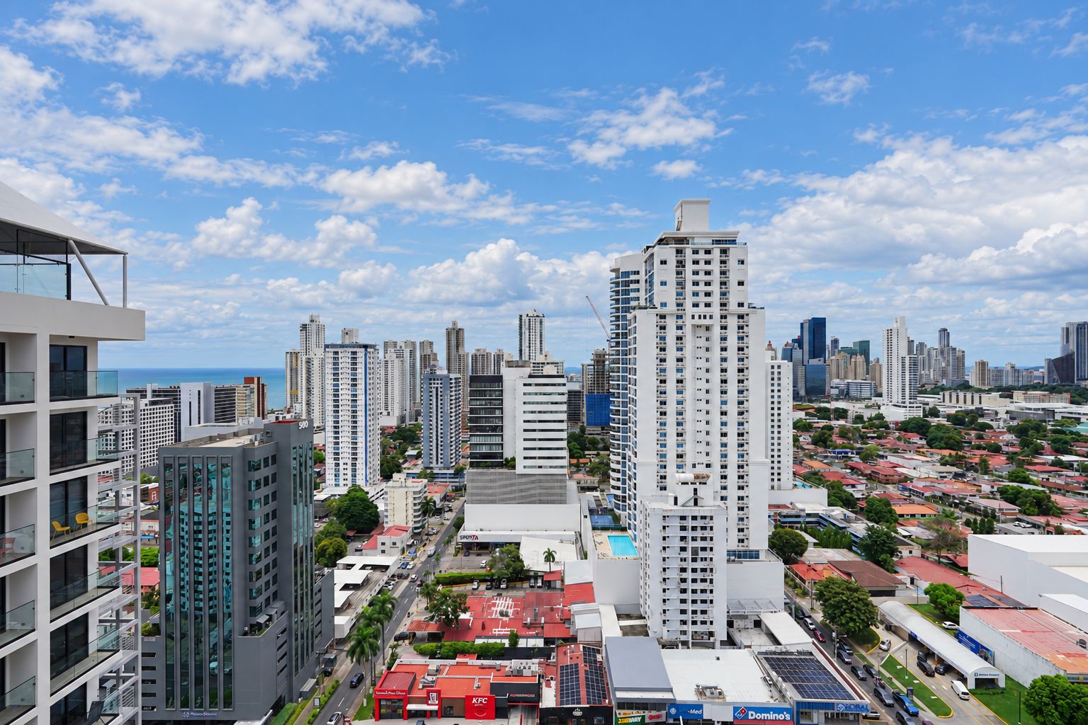 A high-rise building with a modern architectural design, surrounded by other high-rise buildings and a mix of commercial and residential structures.