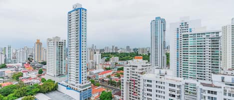 A high-rise residential building with multiple floors, surrounded by other high-rise buildings, indicating a densely populated urban area.