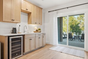 A modern kitchen with wooden cabinets, a built-in oven, and a large sliding glass door leading to an outdoor patio. - Luxury New Build with Lake Norman Views & Resort Amenities- Sleeps 16 (Lake Norman of Catawba)